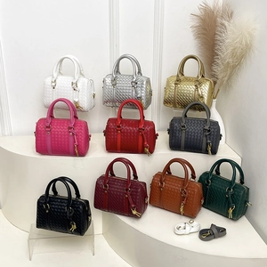 Collection of woven texture boston bags in ten various colors on elegant white shelving