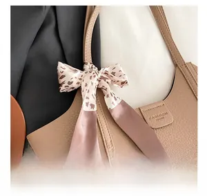 Detail of brown litchi pattern tote bag with leopard print scarf and metal closure