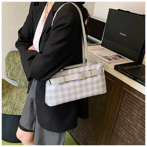 Detail of grey checkered baguette bag with silver buckle and thin leather strap detail