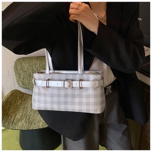 Detailed view of silver plaid baguette bag with buckle and double thin straps on model