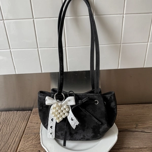 Schicke schwarze Samthandtasche mit weißer Spitzenschleife und Perlenherz-Anhänger