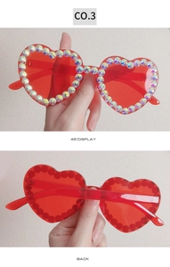 Detail of red heart-shaped sunglasses with colorful rhinestones on the frame