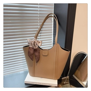 Detail of khaki leather tote with lychee grain texture and stylish leopard print scarf