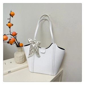 Detail of white lychee leather tote bag with FASHION strap and floral silk scarf