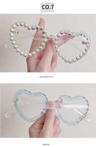 Macro detail of heart-shaped sunglasses with colorful AB rhinestones and clear frame
