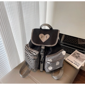 Detail of color-block backpack with heart patch, grid pockets and grey woven straps