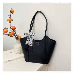 Close-up of black lychee leather tote bag with stylish leopard print silk scarf decoration