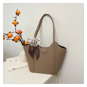 Close-up of khaki tote bag texture with leopard print silk scarf on a handle