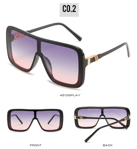 Detail of oversized square sunglasses with gradient purple lenses and gold hinge accents