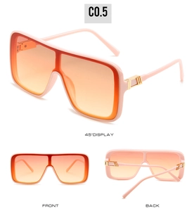 Close-up of pink oversized square sunglasses with orange gradient lenses and gold metal accents