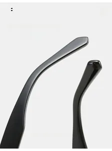 Close-up of curved ergonomic temple on glossy black Y2K oversized sunglasses