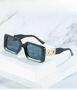 Detail of square sunglasses featuring golden hollow link hinges and glossy black frames
