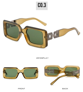Detail view of amber rectangle sunglasses with unique metal chain hinges and green lenses