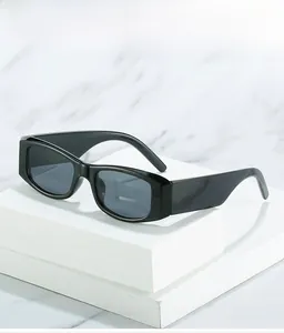 Close-up of retro black rectangular sunglasses with wide temples on a marble base