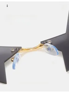 Dettaglio dei naselli blu e del ponte dorato sugli occhiali da sole a stella senza montatura