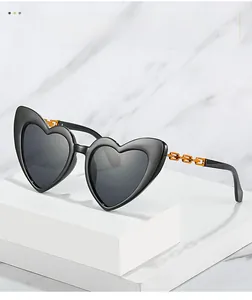 Detail of heart-shaped sunglasses featuring unique orange chain design temples on a display