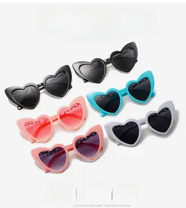 Five heart-shaped sunglasses in assorted vibrant colors laid flat on a white background