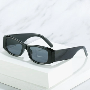 Retro rectangle sunglasses with thick arms and dark lenses on a white marble surface