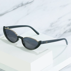 Lunettes de soleil œil de chat noires avec garniture dorée sur fond de marbre