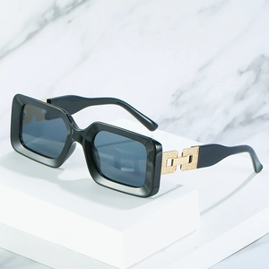 Classic black rectangular sunglasses with gold hollow metal chain detail on white block