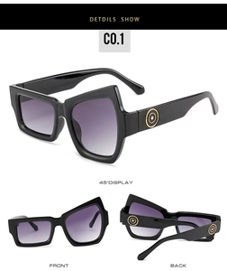 Macro detail of geometric black sunglasses with purple gradient lenses and gold circles