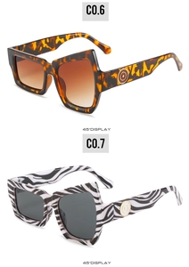 Detail of avant-garde sunglasses with leopard and zebra patterns and circular logo temple