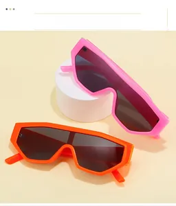 Close-up of pink and orange oversized rimless sunglasses with geometric lenses