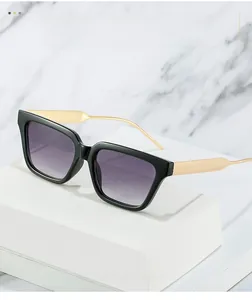 Detail of square sunglasses with black frame, gold metal temples and purple gradient lenses