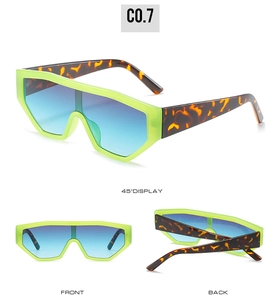 Detail view of neon green oversized sunglasses with gradient lenses and leopard temples