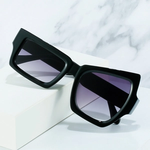 Chic oversized cat-eye sunglasses with black frames and purple gradient lenses on marble
