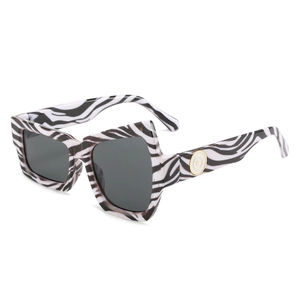 Asymmetric zebra pattern sunglasses with geometric frames and gold metal accents