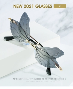 Macro view of grey wing-shaped rimless sunglasses with fine vein textures and gold metal frame