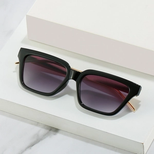 Fashionable square black frame sunglasses with gradient purple lenses on marble surface