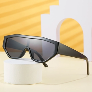 Oversized wrap-around sunglasses in black frame and grey lenses on a minimalist display