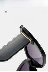Detail of premium gold metal hinge on sleek black wide-frame cat-eye sunglasses