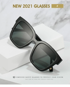 Detail of chunky black square frame sunglasses with golden hinges on marble background