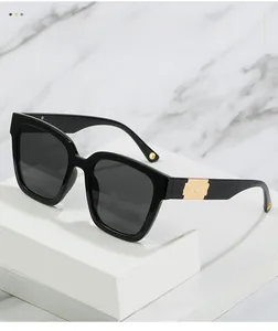 Detail of black sunglasses with polished frames and golden wave pattern metal temples
