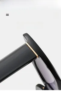Detailaufnahme des goldenen Metallscharniers an der schwarzen Sonnenbrille mit Rahmen