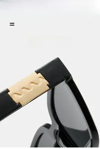 Detail view of square sunglasses featuring golden wave metal accents on thick black temples