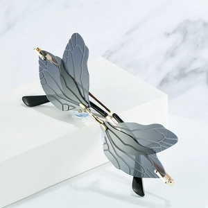 Chic dragonfly wing sunglasses with smoke grey lenses and gold metal frame on display