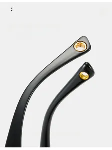 Close-up of curved black sunglasses temple tips with gold circular metal inlay detail