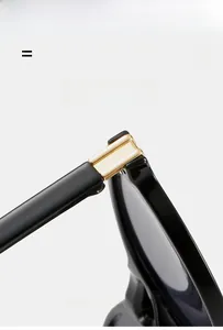 Détail de la charnière en métal doré sur lunettes de soleil rondes noires en matériau flexible