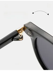 Détail de la charnière en métal doré durable sur des lunettes de soleil noires