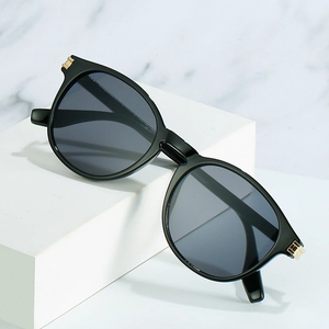 Lunettes de soleil rondes vintage avec monture noire brillante et détails dorés