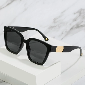 Oversize square sunglasses with black frames and gold wave metal accents on the side