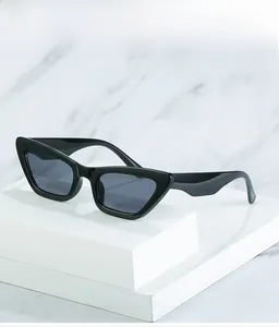 Black cat eye sunglasses on white marble background with minimalist geometric display
