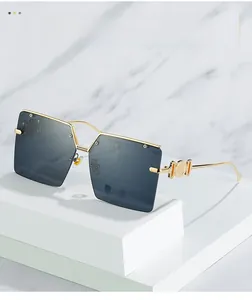 Detail of oversized square sunglasses with gold metal frame and gradient grey lenses