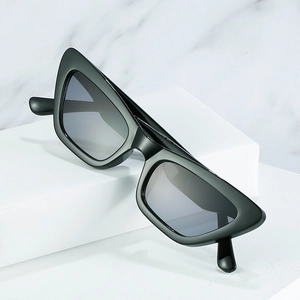 Classic black cat eye sunglasses with thick frames and dark lenses on a marble background