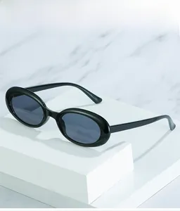 Detailed view of oval vintage sunglasses with thick black frames on a marble background