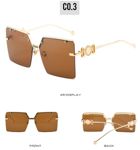 Detail view of oversized square sunglasses with brown gradient lenses and gold temples